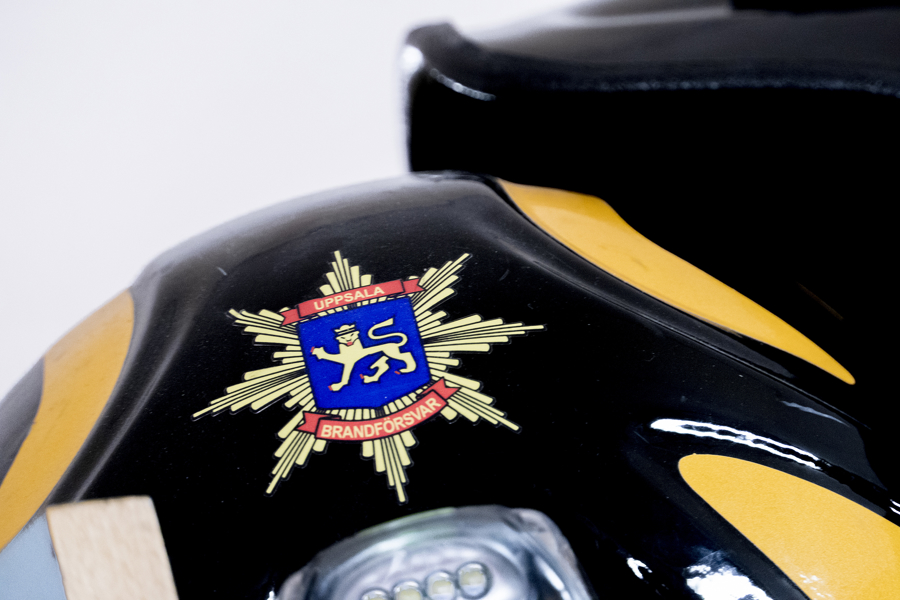En brandmans hjälm i närbild så ett emblem syns